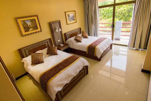 a hotel room with two beds and a window at Hotel La Esperanza in Chitré