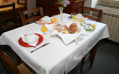 a table with a white table cloth with food on it at Hotel Calzaiolo in San Casciano in Val di Pesa