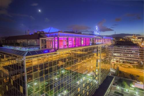 a building with purple lights on top of it at night at Hilton Prague Atrium in Prague