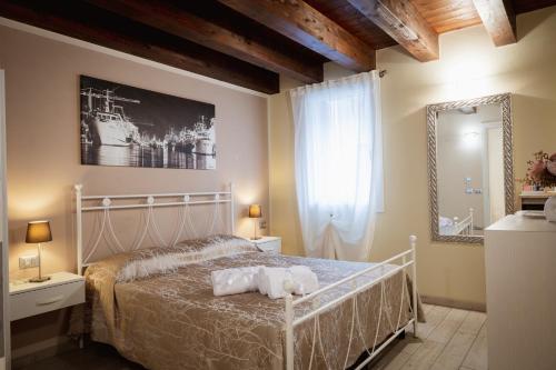 a bedroom with a white bed and a mirror at Piccola Venezia Room in Chioggia