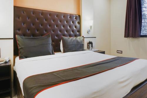 a bedroom with a large bed with a large headboard at Hotel O Span Executive in Pune