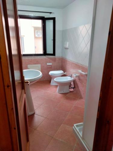 a bathroom with two sinks and a toilet and a window at Casa Antonietta in Santa Lucia