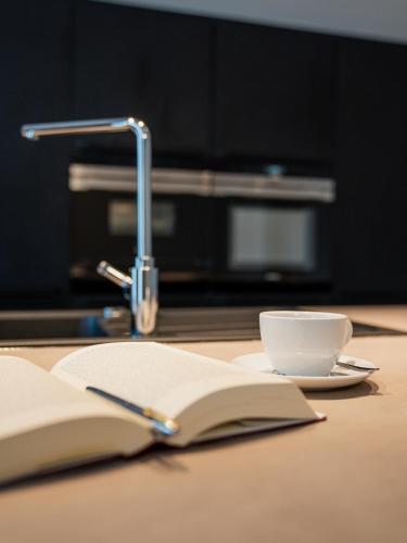 an open book and a cup of coffee on a table at NEU im Zentrum stilvolle Premium-Suite mit Parkplatz in Gummersbach