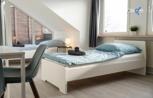 a bedroom with a bed with a desk and a staircase at BEGE APARTMENTS FlowLoft in Wegberg