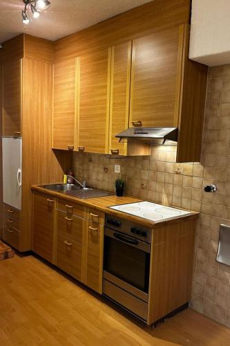 a kitchen with wooden cabinets and a sink and a stove at Apartment Thun Relax Suite by Interhome in Thun