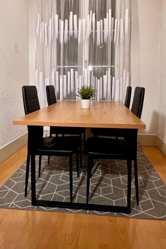 a wooden table with black chairs and a potted plant at Apartment Thun Relax Suite by Interhome in Thun
