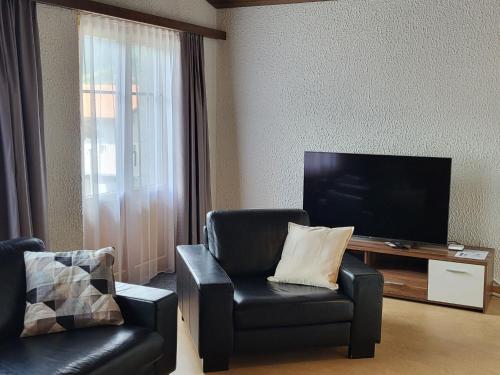 a living room with a chair and a television at Apartment Tgèsa Val by Interhome in Sedrun