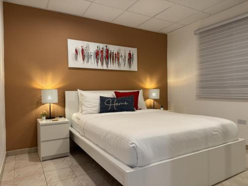 a bedroom with a large white bed and two lamps at Fontana Sunset - Spacious 3BR Family Home in Carolina