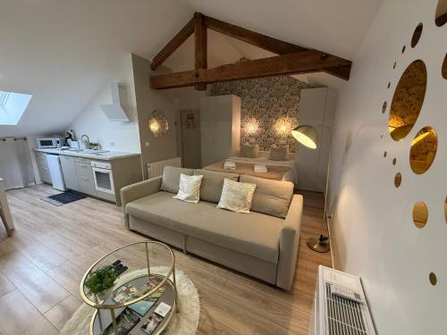 a living room with a couch and a table at Petite Merveille sous les toits - Centre de Dijon in Dijon