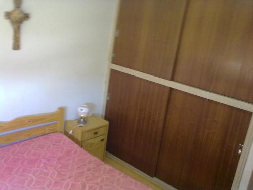 a bedroom with a bed and a wooden closet at SAN CLEMENTE RIAZOr 6 in San Clemente del Tuyú