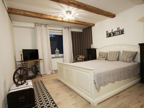 a bedroom with a large white bed and a television at Holiday Home Weideblick by Interhome in Geestland
