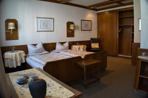 a hotel room with two beds and a table at Weigands Hotel Peter in Reinhardshagen