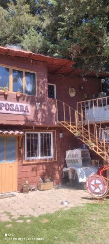 a house with a staircase and a truck parked in front of it at Posada "Villa Biker" in Villa del Carbón