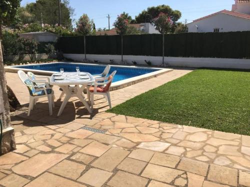 a patio with a table and chairs next to a pool at Holiday Home Casa Blumer by Interhome in Les tres Cales