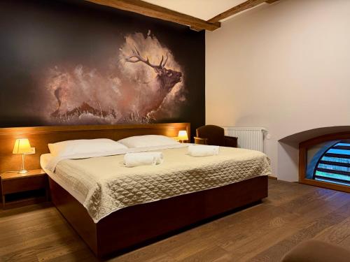 a bedroom with a bed with a painting on the wall at Hotel Chateau Orlice in Letohrad