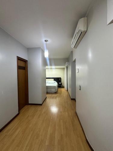 an empty room with a bed and a wooden floor at Urban II - Cómodo monoambiente en pleno centro in San Juan