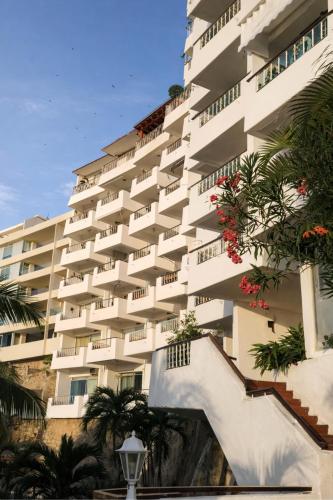 a large white building with stairs in front of it at Bella Brisas Stays in Acapulco