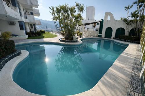 a swimming pool in front of a building at Bella Brisas Stays in Acapulco
