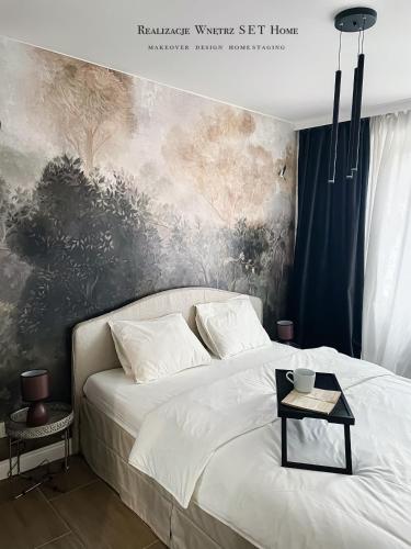 a bedroom with a bed with a painting on the wall at Stobrawa premium 2 in Kluczbork