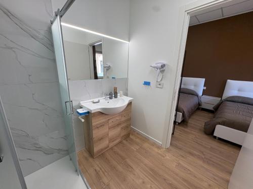 a bathroom with a sink and a mirror at Elco Rooms Malpensa in Lonate Pozzolo