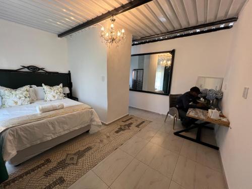 a man sitting at a table in a bedroom at La Grande in Benoni
