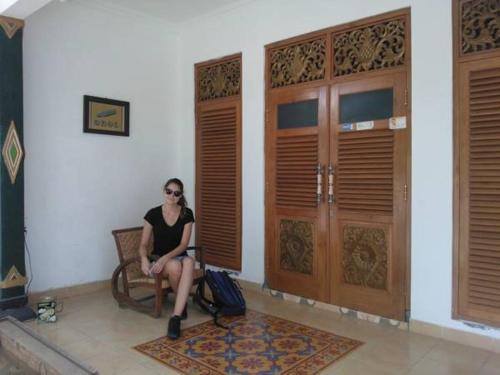a woman sitting on a chair in a room at Rumah Desa Homestay in Prambanan