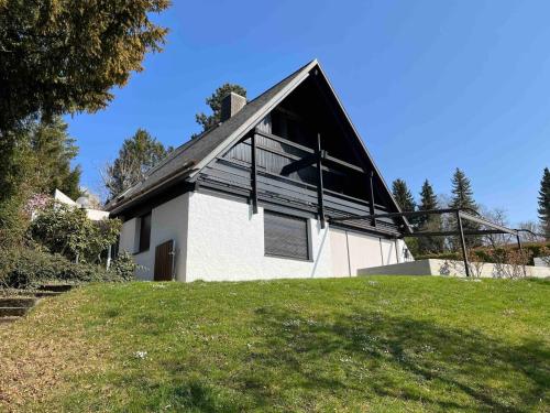 a white house with a black roof on a hill at Holiday Home mit Pool by Interhome in Nürtingen