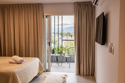 a bedroom with a bed and a view of a balcony at Cañada Suites by FMA Coliving in Salta