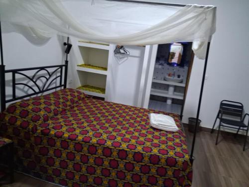 a bedroom with a bed with a canopy at keur Baye fall fall saly in Sali Nianiaral