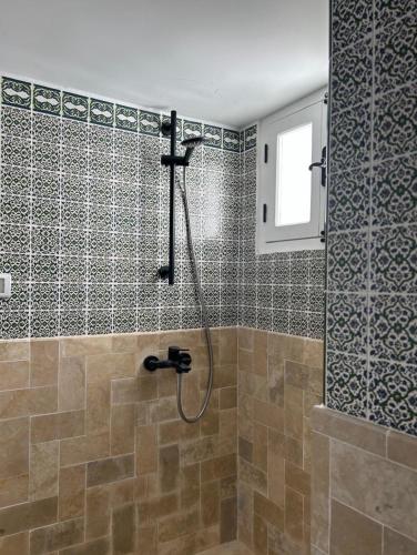 a bathroom with a shower with a glass door at Guesthouse DarHamdoun in Ḩammām al Ghazzāz