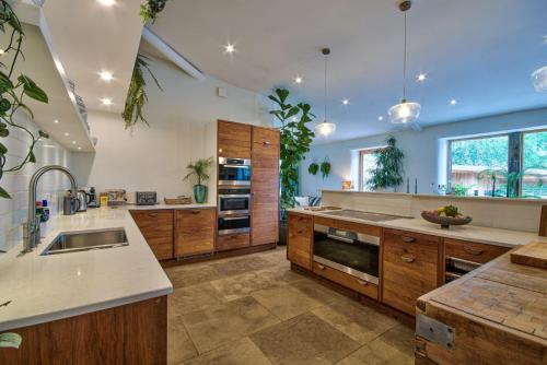 a large kitchen with wooden cabinets and a sink at Olive Orchard in Cropredy