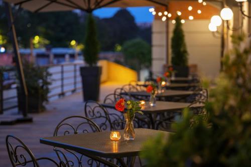 a row of tables and chairs with flowers in a vase at Starhotels Du Parc in Parma