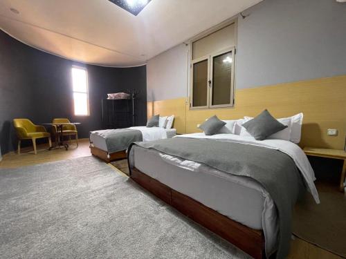 a bedroom with two beds and a table and chairs at Palm Garden in Erfoud