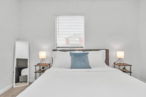 a bedroom with a large white bed with two lamps at Spacious-2BR2BA- King Ensuite- PVT Patio in Houston