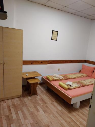 a bedroom with a bed and a wooden table at Скай Румс -2 in Sofia