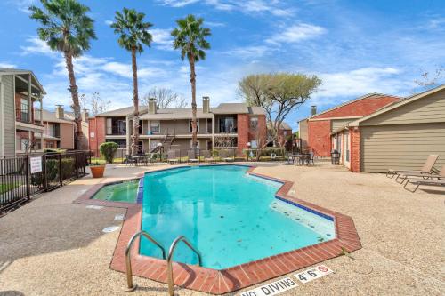 a swimming pool in a yard with palm trees at Spacious-2BR2BA- King Ensuite- PVT Patio in Houston