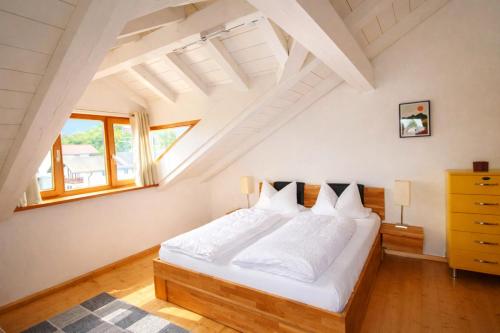 a bedroom with a large white bed in a attic at ChiemseeRefugium - Ferienwohnung Park in Bernau am Chiemsee