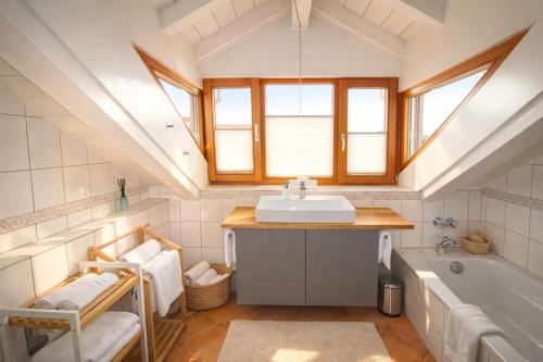 a bathroom with a sink and a bath tub at ChiemseeRefugium - Ferienwohnung Park in Bernau am Chiemsee