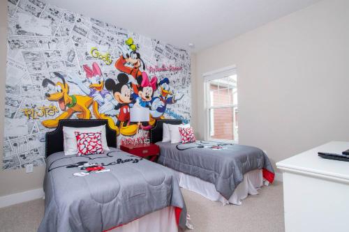 a bedroom with two beds and a mural of mickeys at Gorgeous 4 Bedroom Family Friendly Close to Disney 7573 in Orlando