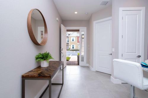 a hallway with a mirror and a wooden table at Gorgeous 4 Bedroom Family Friendly Close to Disney 7573 in Orlando