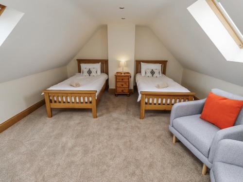 a attic room with two beds and a couch at High Hemmel House in Embleton