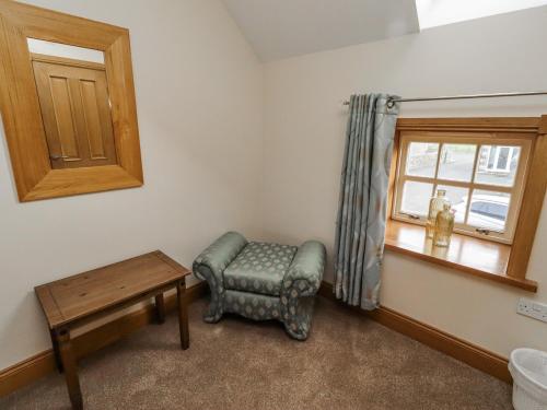 a room with a chair and a window at High Hemmel House in Embleton
