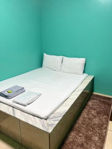 a bed in a room with a blue wall at Pousada Vitória in Iranduba