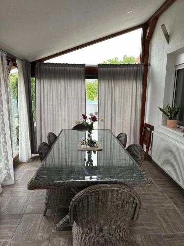 ein Esszimmer mit einem Glastisch und Stühlen in der Unterkunft Tiva kucazaodmor-Fruska Gora in Šuljam