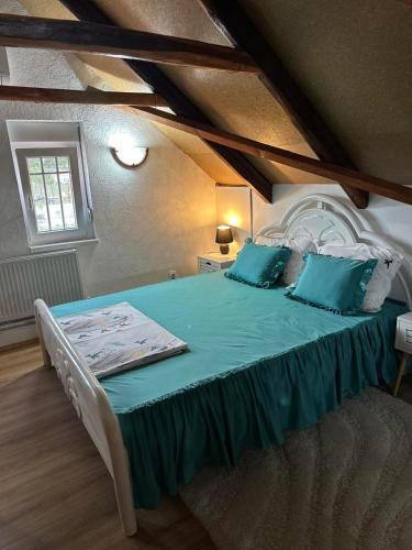 ein Schlafzimmer mit einem großen Bett und blauen Kissen in der Unterkunft Tiva kucazaodmor-Fruska Gora in Šuljam