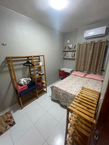 a small bedroom with a bed and a shelf at Apartamento Império das Marés in Paracuru