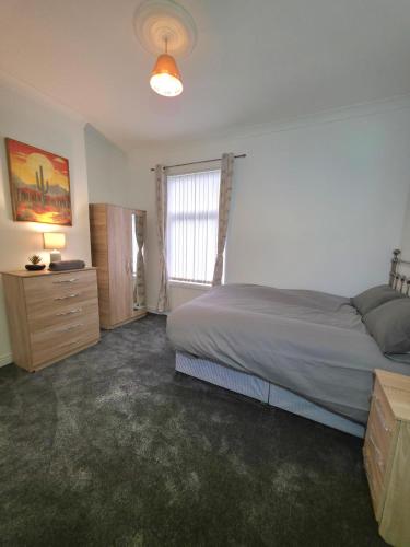 a bedroom with a bed and a window at Costa Home - 3 bed house with free on-street parking - ideal for workers in Middlesbrough