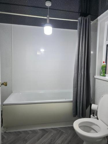 a bathroom with a bath tub and a toilet at Costa Home - 3 bed house with free on-street parking - ideal for workers in Middlesbrough