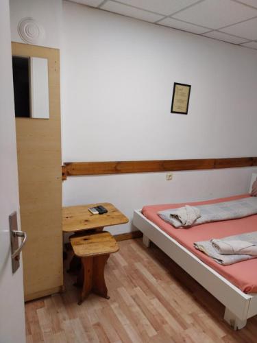a room with two beds and a wooden table at Скай Румс -3 in Sofia