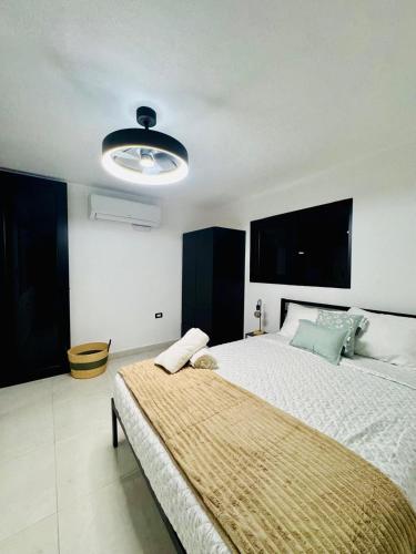 a bedroom with a large bed and a light at Brand New Luxe 2BR Apt Near SJU & Airport in Carolina